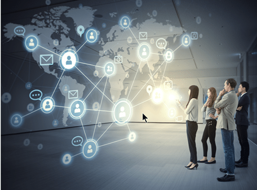 Executives looking at a projection of a world map and interlocking network of icons.