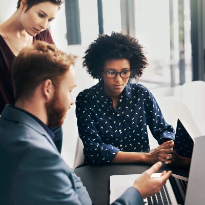 Group of colleagues using a laptop discussing cybersecurity games