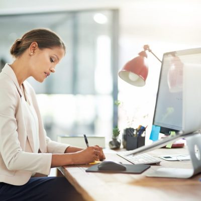 Business woman working at desk representing it security risk assessments